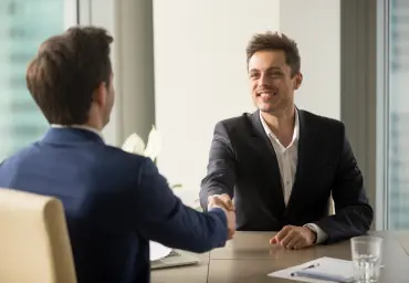 Business Handshake Symbolizing a Successful Agreement Two business professionals shaking hands in an office, symbolizing a successful interview or business agreement